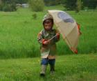 Αγόρι με ομπρέλα του και αδιάβροχο πλαίσιο της άνοιξης βροχή